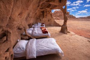 a group of beds in a cave in the desert at Wadi Rum Cave Camping in Wadi Rum