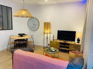 a living room with a couch and a tv at Confort à Loulé in Loulé