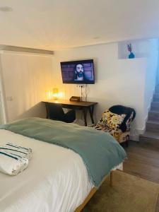 a bedroom with a bed and a tv on the wall at Confort à Loulé in Loulé