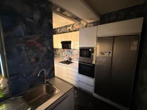 a kitchen with a stainless steel refrigerator and a sink at Sylla in Dakar