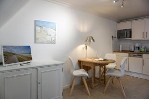 a kitchen with a table and chairs in a room at Westerhoern 46 Haus 2 App 24 in Keitum