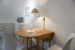 a dining room table with white chairs and a lamp at Westerhoern 46 Haus 2 App 24 in Keitum