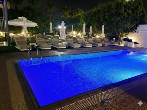 a swimming pool with lounge chairs and a blue pool at NissiLant hotel & suites in Ayia Napa