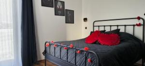 a bedroom with a black bed with red pillows at Red Room Luxury puhkemaja in Kooli