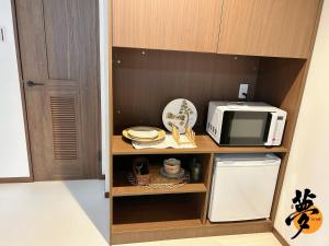 a small kitchen with a microwave and a refrigerator at Yume夢 堺店 in Sakai +40 photos