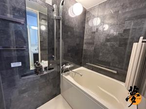 a bathroom with a tub and a sink and a mirror at Yume夢 堺店 in Sakai