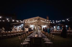 a long table with chairs and lights at a wedding at Agriturismo Podere Santo Stefano in Cinigiano