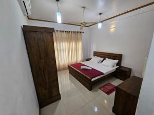 a bedroom with a bed and a large window at Queens Residence Homestay in Kandy +9 photos