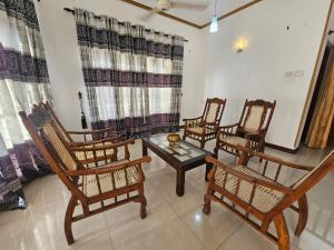 a group of chairs and a table in a room at Queens Residence Homestay in Kandy
