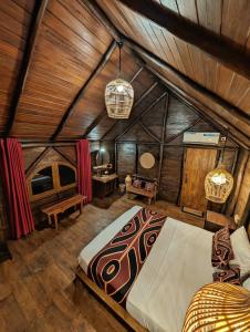 a bedroom with a large bed in a wooden ceiling at Gaga Bees Udawalawe in Udawalawe