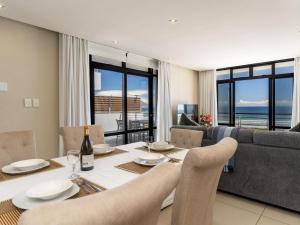 a dining room with a table and a couch at 167 Eden on the Bay in Big Bay