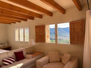 a living room with a couch and a window at Aldea Roqueta Hotel Rural in Els Ibarsos