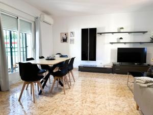 a living room with a table and chairs and a television at El Retiro de Albarreal - Chalet 3 hab, Aire Acondicionado y Entrada Piscina Gratuita in Albarreal de Tajo