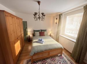 a bedroom with a bed and a chandelier at Gawra Bogusza in Lądek-Zdrój