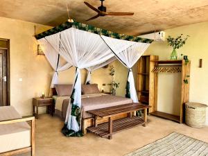 a bedroom with a bed with a mosquito net at Afro Divers Lodge in Miperani +83 photos