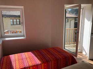 a bedroom with a bed and a window with a balcony at Dimora Concordia in Calavino