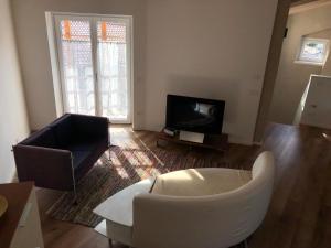 a living room with a white couch and a tv at Dimora Concordia in Calavino