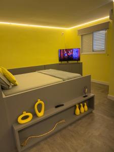 a bedroom with a bed with a yellow wall at Flat Red Sorocaba - Yellow in Sorocaba