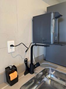 a kitchen counter with a sink with a microwave at Flat Red Sorocaba - Yellow in Sorocaba
