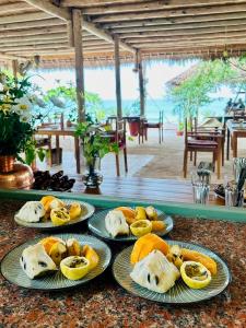 a table with four plates of food on it at Afro Divers Lodge in Miperani