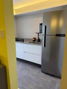 a kitchen with a stainless steel refrigerator at Flat Red Sorocaba - Yellow in Sorocaba