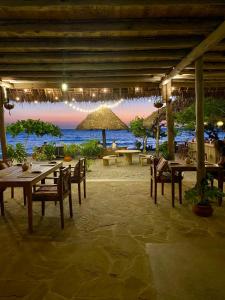 a restaurant with tables and chairs and a view of the ocean at Afro Divers Lodge in Miperani