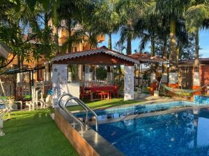 a swimming pool with a gazebo next to a house at Green Paradise - Trimbakeshwar in Trimbak