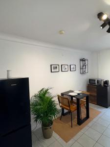 a dining room with a table and a table and a plant at Apartment Café Ettelbrück in Ettelbruck