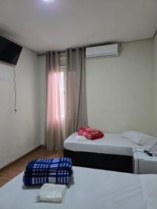a room with two beds and a window at Hotel Santos Inn in Santos