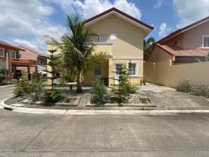 a house with a palm tree next to a street at AD3M Haven's Place in Bantug