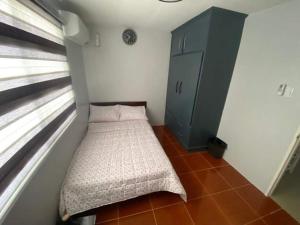 a small room with a bed next to a window at AD3M Haven's Place in Bantug