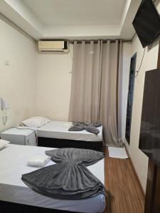 a small room with two beds and a television at Hotel Santos Inn in Santos +9 photos