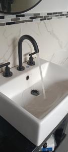 a white kitchen sink with a faucet at Loft Moderno in Viedma +38 photos