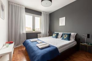 a bedroom with a bed with blue sheets and a window at Reda Cozy Nest Apartment by BookingHost in Reda