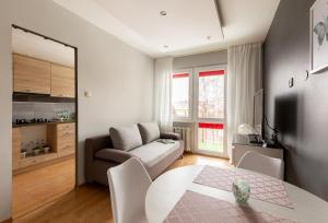 a living room with a table and a couch at Reda Cozy Nest Apartment by BookingHost in Reda