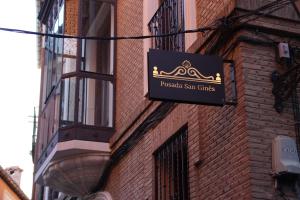 a sign on the side of a brick building at San Ginés Rooms Self Check-In in Toledo +70 photos