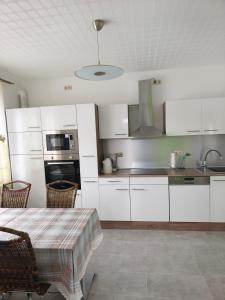 a kitchen with white cabinets and a table with chairs at Marina in Bleckede