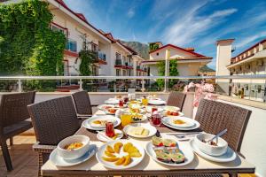 ein Tisch mit Frühstücksspeisen auf einem Balkon in der Unterkunft Sunshine Holiday Resort in Oludeniz