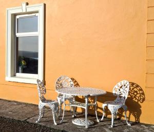 a table and four chairs next to a window at Shannonview Country House in Labasheeda