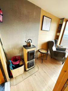 a living room with a stove and a chair at Glampeak Adamov in Adamov