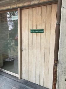 a door to a house with a sign on it at De Notelaar in Alveringem