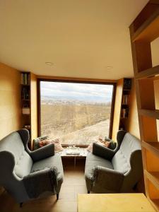 a living room with two chairs and a large window at Glampeak Adamov in Adamov