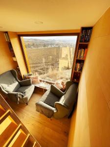 a room with two couches and a large window at Glampeak Adamov in Adamov
