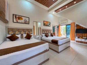 a bedroom with two beds and a large window at Green Paradise - Trimbakeshwar in Trimbak +143 photos