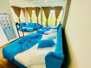 a room with four beds and a blue couch at Resolve Garden Hotel in Dodangoda +86 photos