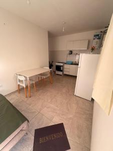 a small kitchen with a table and a refrigerator at Solares de Sabatini in Villa del Totoral +7 photos