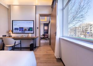 a room with a desk and a large window at Atour X Hotel Shenyang Beiling Park in Shenyang