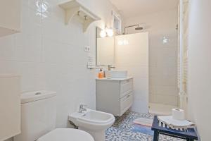 a white bathroom with a toilet and a sink at Winahost Apartament Cirerer in Valldoreix +14 photos