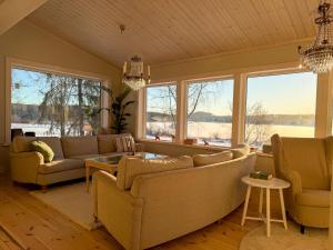 a living room with couches and a large window at Secluded Lakehouse in Falun