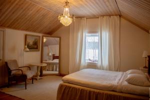 a bedroom with a bed and a window and a chandelier at Secluded Lakehouse in Falun
